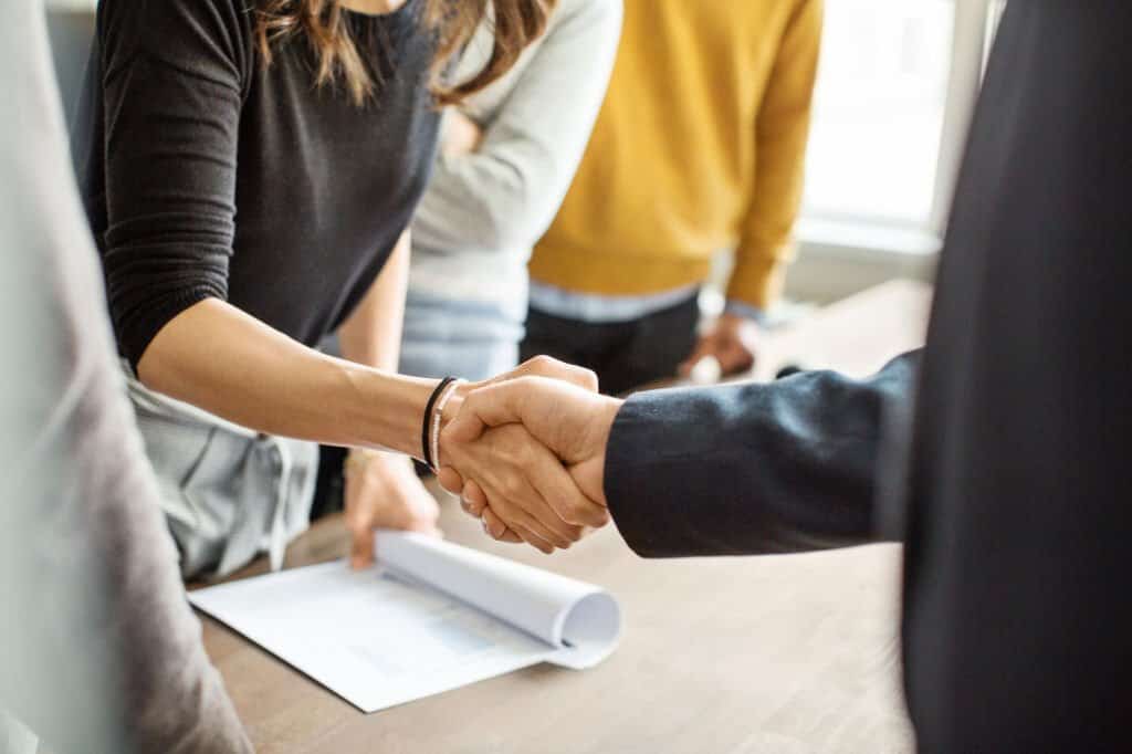 Close up of business people shaking hands in office